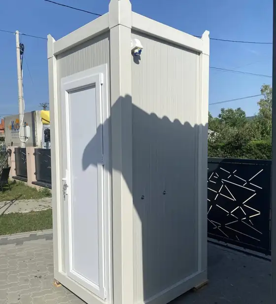 White cabin-style deluxe flushing restroom unit on a lawn