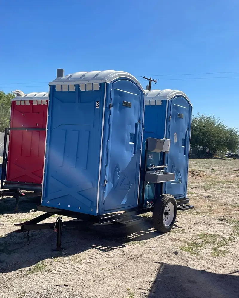 Several portable toilets strapped onto a flatbed delivery trailer