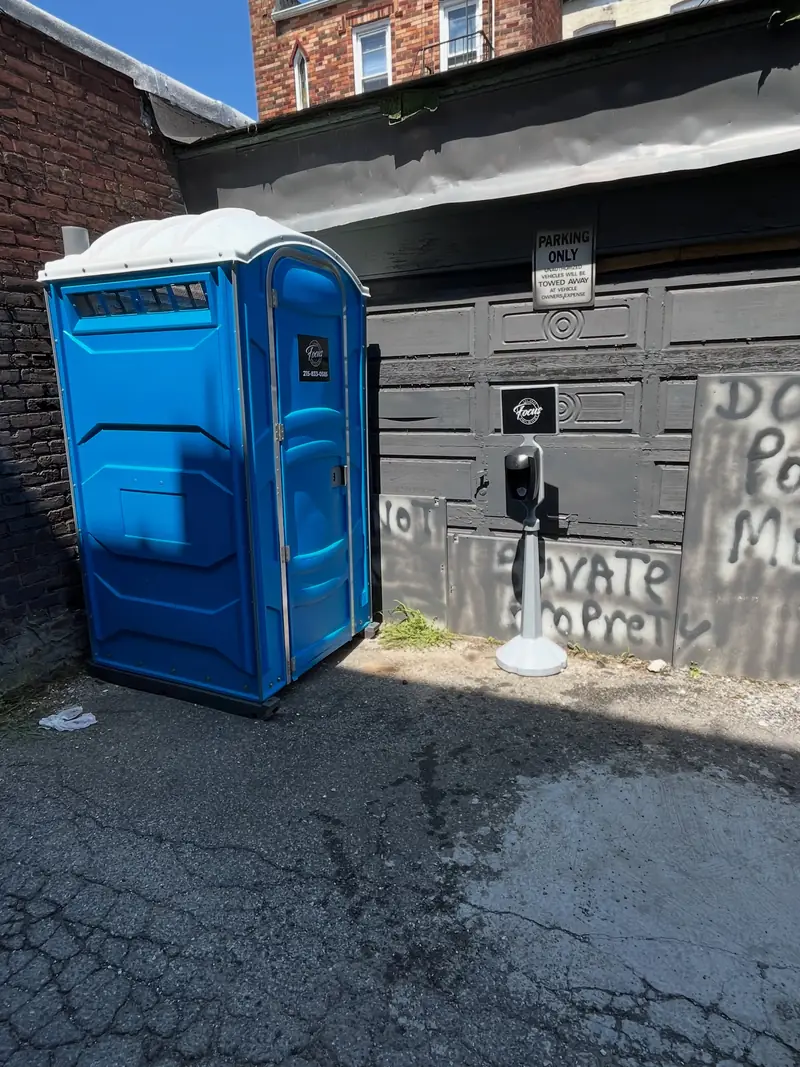 Portable toilet placed on a paved driveway