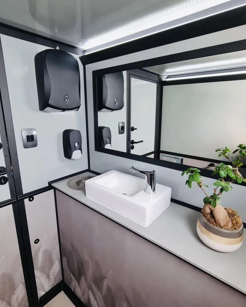 Sink and mirror inside a wedding restroom trailer.
